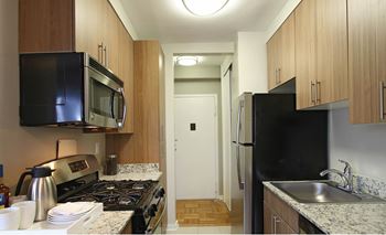 a kitchen with a black refrigerator freezer next to a stove top oven